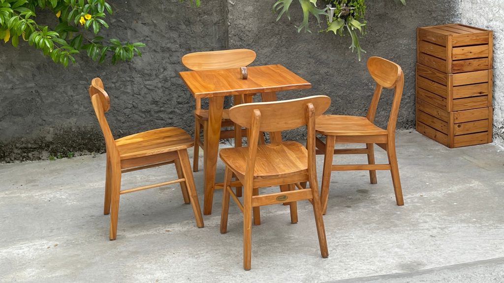 Ensemble de mobilier en bois moderne dans un jardin, montrant l'évolution du mobilier avec des chaises et une table au design épuré.