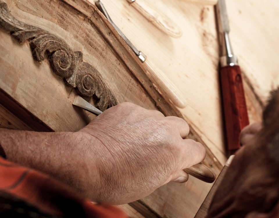 Artisan ébéniste sculptant un meuble en bois avec précision - Techniques de restauration de meubles anciens